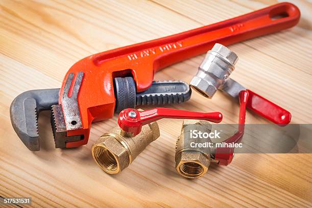 Plumbing Fixtures And Monkey Wrench On Wooden Board Stock Photo - Download Image Now