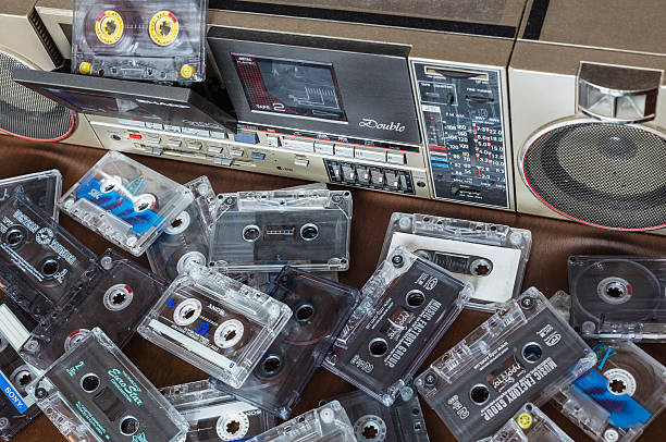 Old cassette tape recorder Sharp with cassettes. Zhytomyr, Ukraine, 24 March 2016. Cassette tape recorder Sharp model QT-90ZG with cassettes. The tape recorder was made in Japan for export. Cassettes are scattered on the table near the tape recorder.  sharp corporation stock pictures, royalty-free photos & images