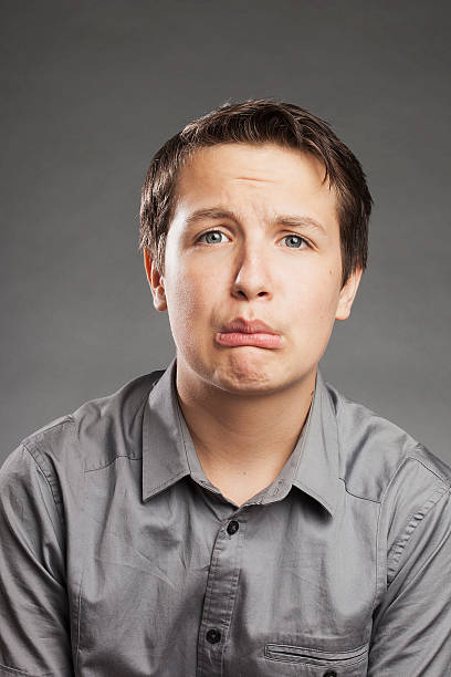 istock Teenager boy against gray background, sad 517534005