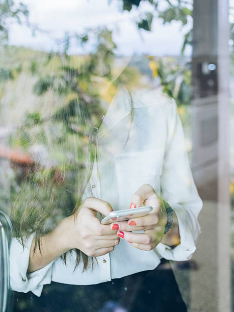 istock standing asian woman checking phone messages 517534756