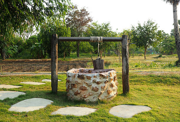 Old countryside water well. Old countryside water well With Pulley and Bucket. wells stock pictures, royalty-free photos & images