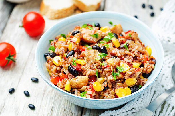 Black beans, corn and tomato red and white rice with chicken Black beans, corn and tomato red and white rice with chicken. toning. selective focus beans and rice stock pictures, royalty-free photos & images