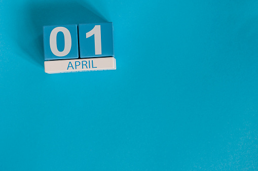 April 1st. Image of april 1 wooden color calendar on blue background.  Spring day, empty space for text. All Fool's Day.