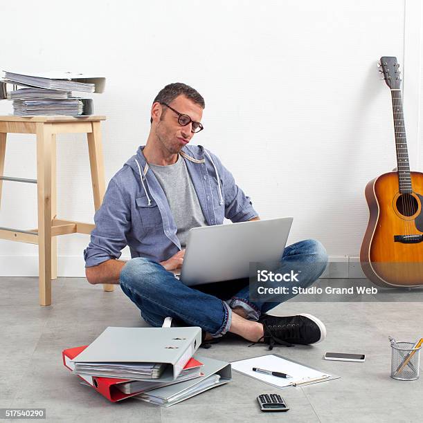 Creative Startup Entrepreneur Working His Budget On The Floor Stock Photo - Download Image Now