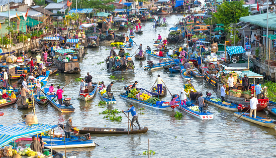 Soc Trang, Vietnam - February 3rd, 2016: Buying and selling agricultural products on river crowded with boats fruit, flowers, agricultural products on busiest floating market in Soc Trang, Vietnam