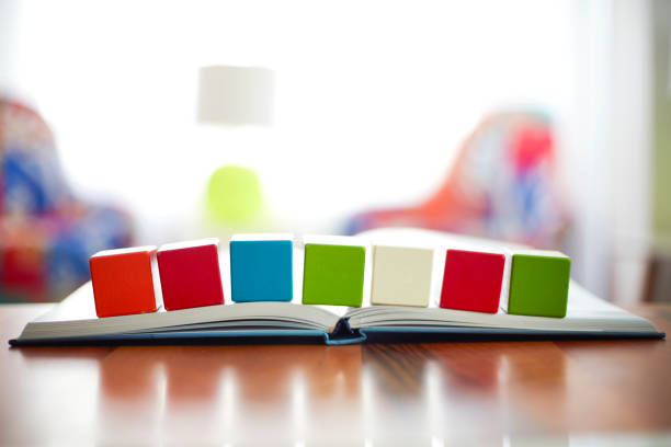 Seven Blank building blocks placed on the open book, ready to write words