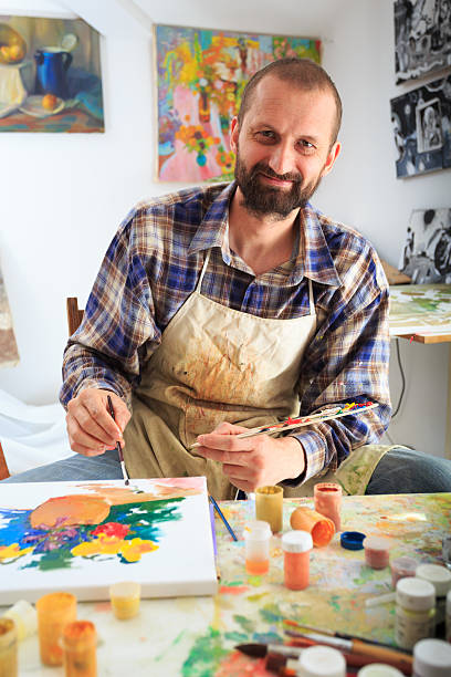 istock Smiling artist with paint palette working at his studio 517545244