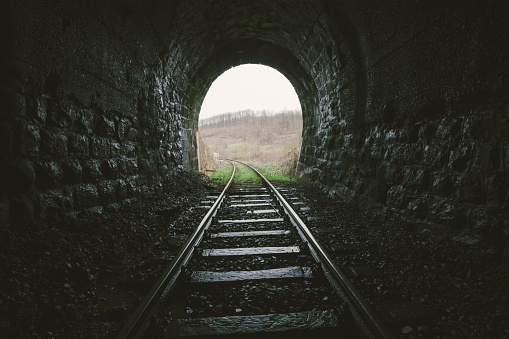 Exit from an old railroad tunnel. Photo is taken with dslr camera and wide angle lens on some old railroad track in Europe. Kodak portra filter applied in post processing.