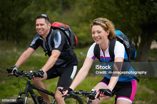 Man And Woman Enjoying A Bike Ride In Nature Stock Photo - Download Image Now - 30-39 Years, 40-49 Years, Active Lifestyle