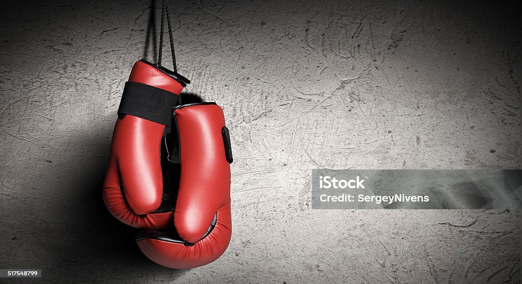 Boxing gloves Pair of red boxing gloves hanging on wall Boxing - Sport Stock Photo