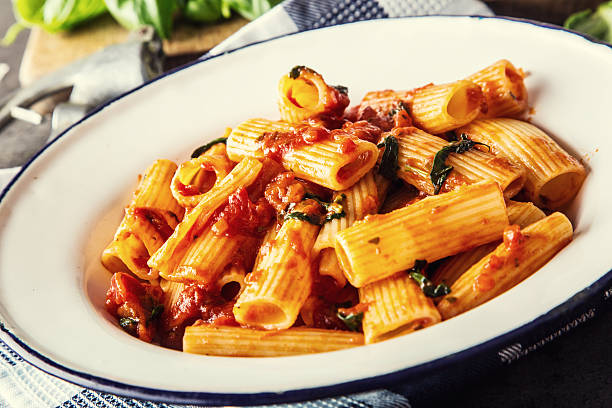 istock Pasta Rigatoni with tomato sauce basil leaves and parmesan cheese. 517548852
