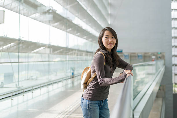 istock Young Asian woman relaxing against railing 517550735