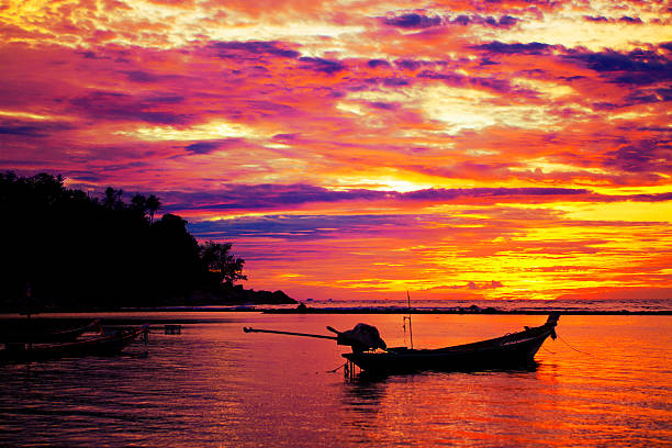 Beautiful tropical sunset, paradise looking beach and ocean with longtail boats. Thailand, Ko Phangan.