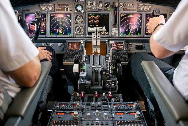 Co-pilot flying an aircraft Co-pilot or first officer is flying commercial airplane Boeing 737-800. boeing 737 photos stock pictures, royalty-free photos & images