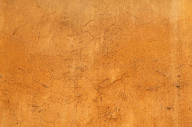 istock Texture of old wall covered with yellow stucco 517554633