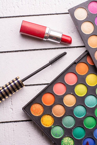 istock Eye shadow, red lipstick and mascara on a white wooden 517569254