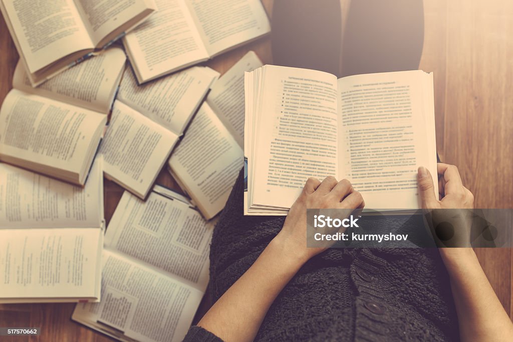 Femme de lecture de quelques livres sur le plancher - Photo de Littérature libre de droits