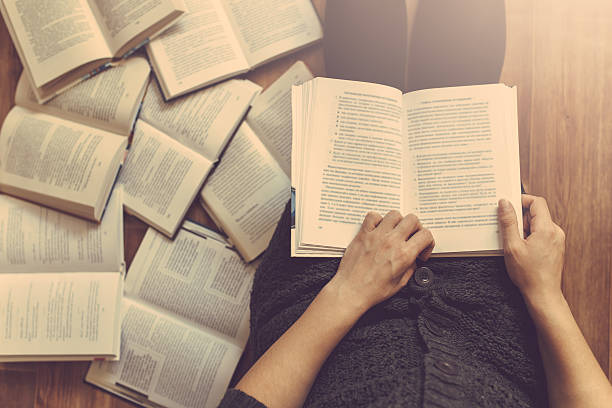 istock Woman reading a few books on the floor 517570662