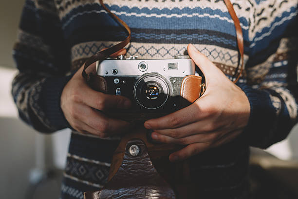 istock Man holding old retro camera in hands 517571674