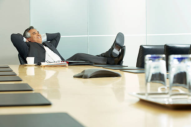 Businessman in a conference room Businessman in a conference room legs crossed at ankle stock pictures, royalty-free photos & images