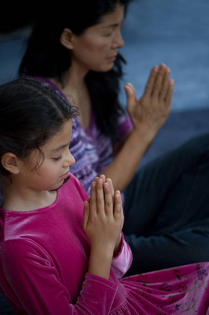 istock Asian mother and Eurasian  daugher in prayer 517575253