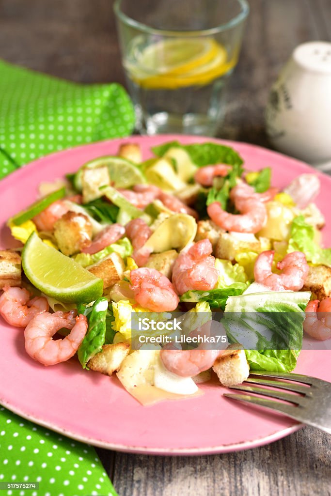 Caesar salad with shrimps and cheese. Caesar salad with shrimps and cheese on rustic background. Appetizer Stock Photo