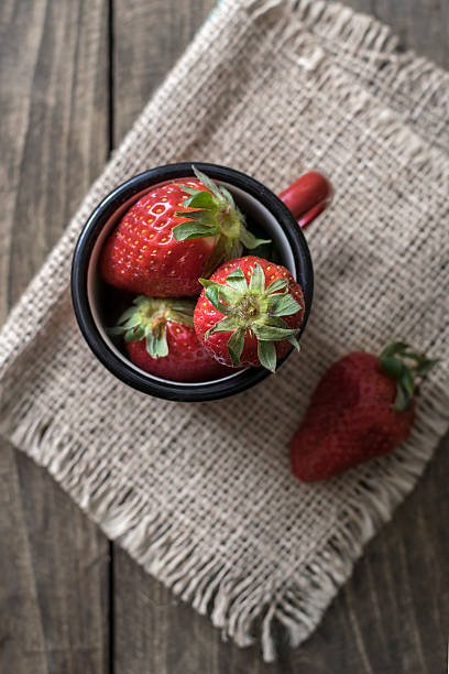 istock Vintage enamel mug filled with fresh strawberries 517575564