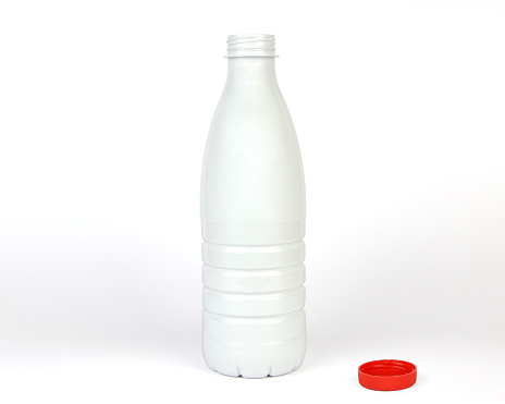 Opened white plastic bottle with red cap on white background