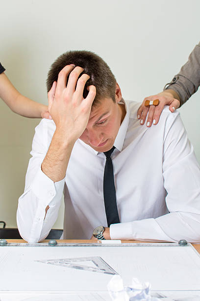 istock Supporting a moody businessman at work 517576658