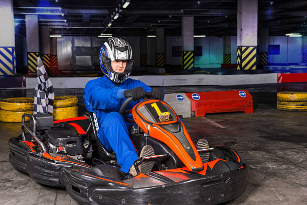 istock Man in blue suit and helmet seated on bumper car 517576894