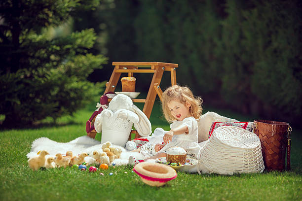 istock Happy child sits on a meadow around Easter decoration 517577252