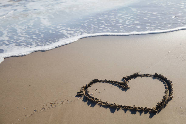 istock Heart drawn on the sand at the beach 517577334