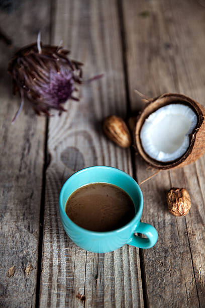 Cup of coffee on wooden background, with flower and nuts