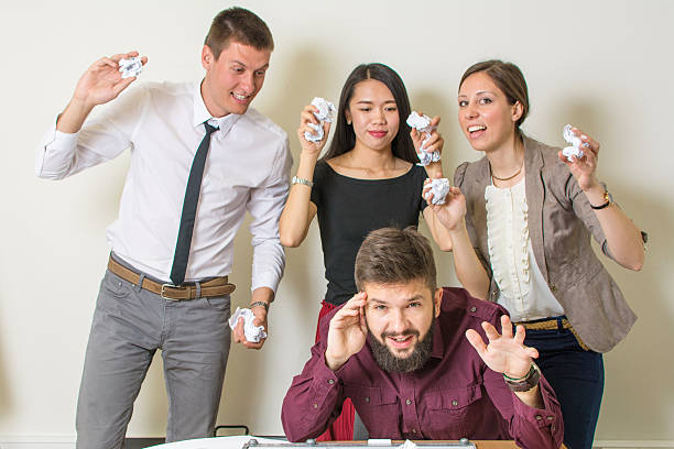 istock People throwing papers on a colleague 517577624