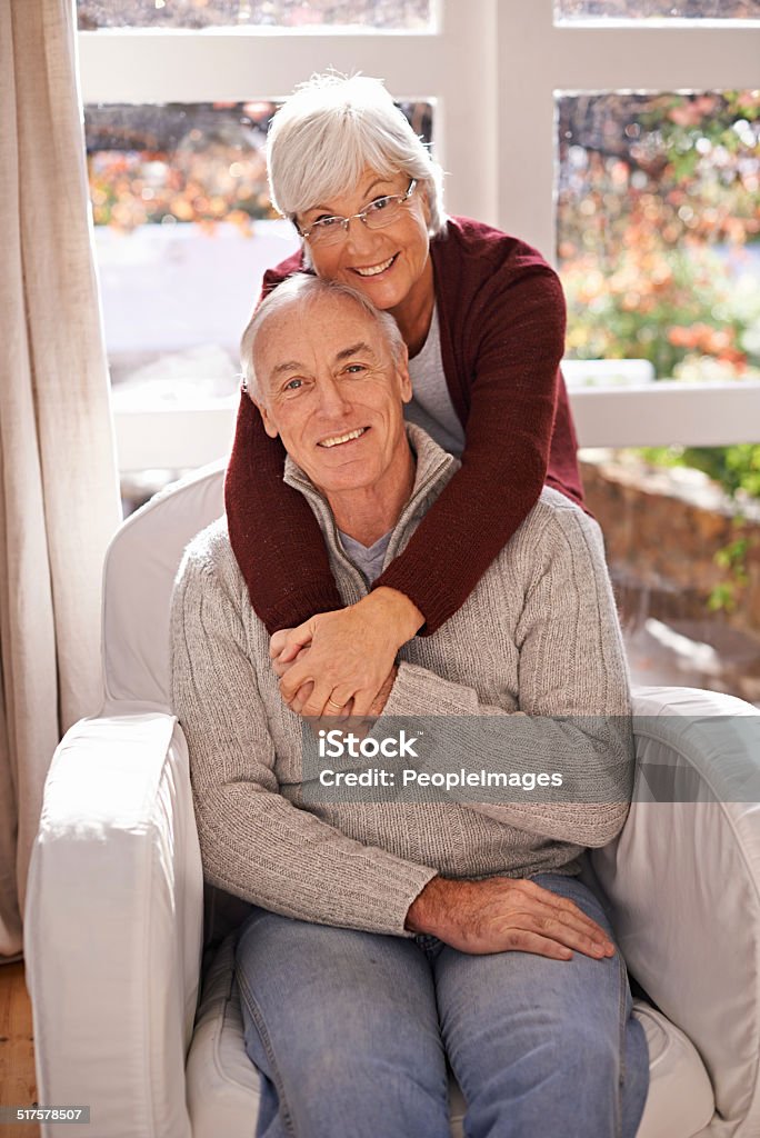 An inseparable pair A portrait of a happy mature couple spending time together at home Armchair Stock Photo