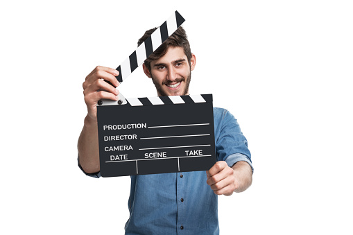 Young man holding a clapperboard over isolated white background. Studio Shot, Horizontal Composition, Image taken with Sony A7RII camera system and developed from camera RAW.