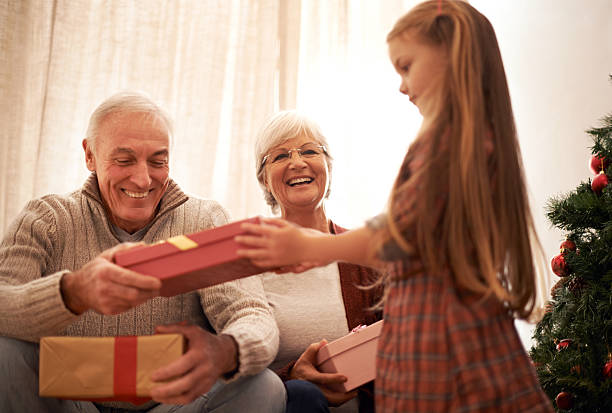 santa's little auxiliar é trazer os presentes - grandmother giving gift child imagens e fotografias de stock