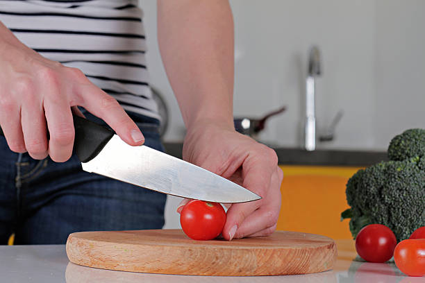 istock Woman cutting tomato, making salad close up. 517581054