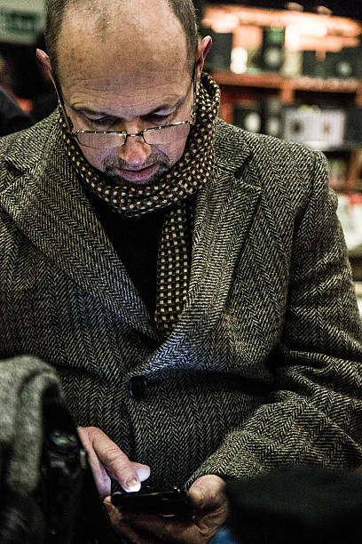 istock mature man sending text message in bar 517581990