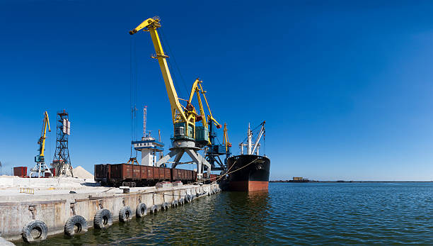 cargo ship in the port cargo ship on loading in sea port of Mariupol - big panorama mariupol stock pictures, royalty-free photos & images