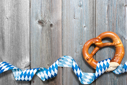 Bavarian pretzels with ribbon on wooden board as a background for Beer Fest