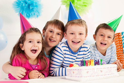 Four happy children celebrating a birthday