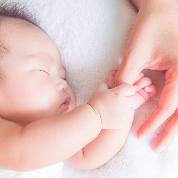 istock sleeping baby holding mom hand 517594003