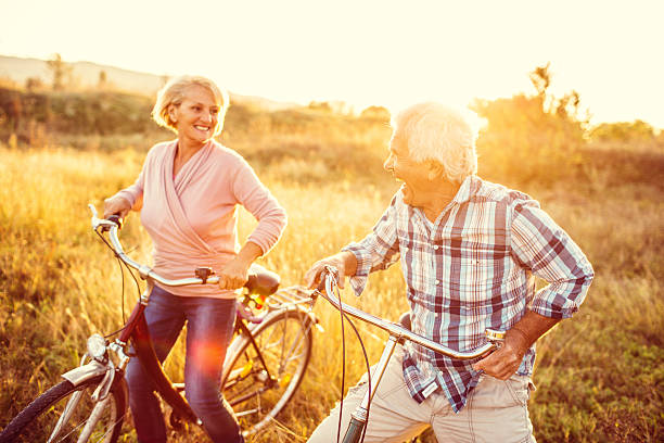 笑顔年配のカップルのサイクリングマシン - retirement mature couple couple bicycle ストックフォトと画像