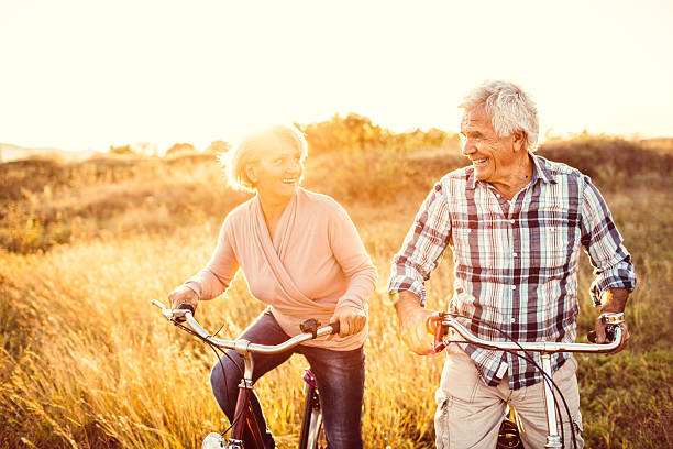 アクティブでは、ゴールドの年 - retirement mature couple couple bicycle ストックフォトと画像