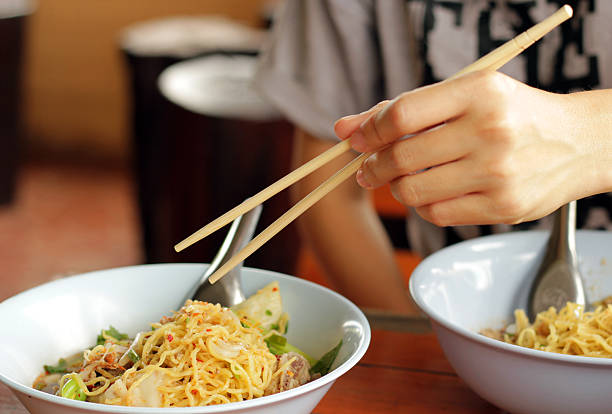 Use chopsticks for eat noodles.