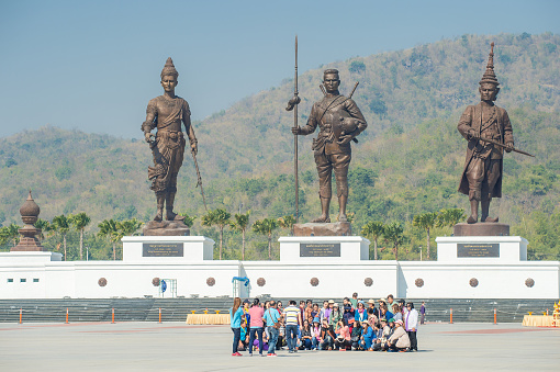 Hua Hin, Thailand - January 28, 2016: Tourists take a group photo at Rajabhakti Park in Hua Hin. Rajabhakti Park is a new landmark and tourist attraction displaying giant bronze statues of seven historic Thai kings.