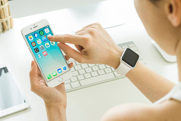 Woman Holding iPhone 6s Over the Table stock photo