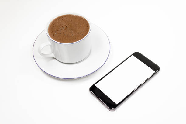 Smartphone with cup of coffee on isolated background.