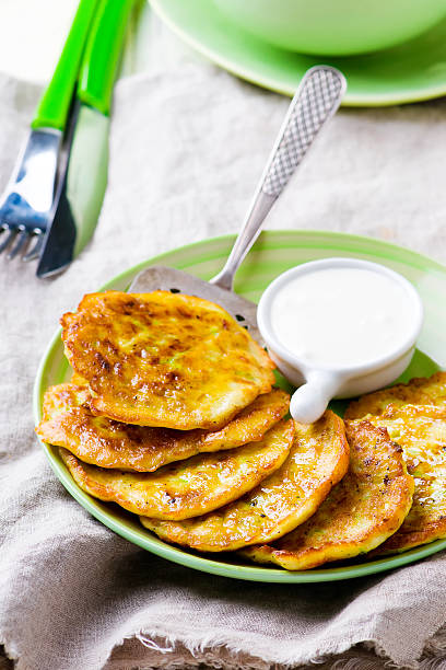 istock vegetable marrows fritters with sour cream on a green plate. 517610872
